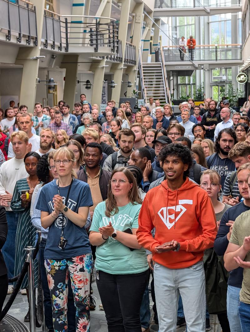 Masse studenter i et universitetsbygg. 